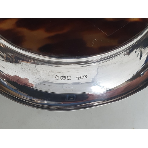 81 - A George V silver and tortoiseshell circular Dish with musical trophy and ribbon decoration, London ... 