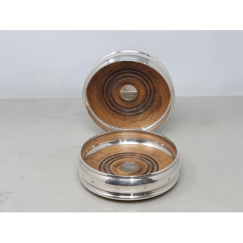 87 - A pair of modern silver circular Coasters with turned wooden bases, London 1991