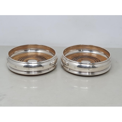 87 - A pair of modern silver circular Coasters with turned wooden bases, London 1991
