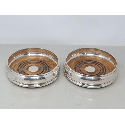 87 - A pair of modern silver circular Coasters with turned wooden bases, London 1991