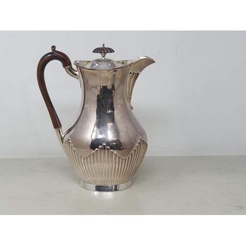 92 - A Victorian silver Hot water Jug of oval semi-fluted form with ebonised handle, Sheffield 1893, 630g... 
