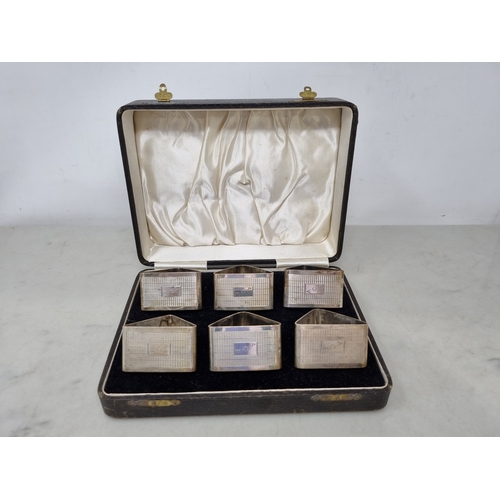 107 - Six George VI silver triangular Napkin Rings with engine turning and engraved initials, Birmingham 1... 