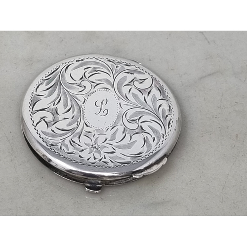 85 - A sterling silver circular Powder Compact with leafage scroll engraving  and initial, maker: Birks