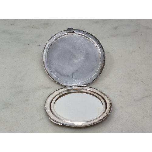 85 - A sterling silver circular Powder Compact with leafage scroll engraving  and initial, maker: Birks