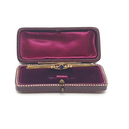 255 - An Edwardian Bar Brooch set step-cut sapphire between trios of seed pearls, marked 15ct, approx 6.5c... 