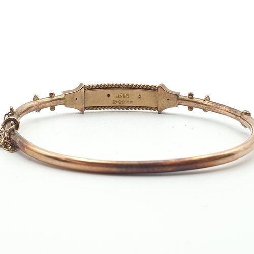 265 - A 9ct gold hinged  Bangle the front single diamond between two round rubies, approx 6gms and a hinge... 