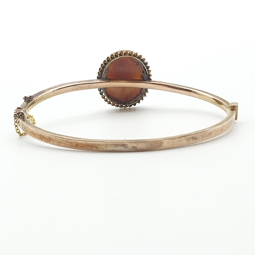 265 - A 9ct gold hinged  Bangle the front single diamond between two round rubies, approx 6gms and a hinge... 