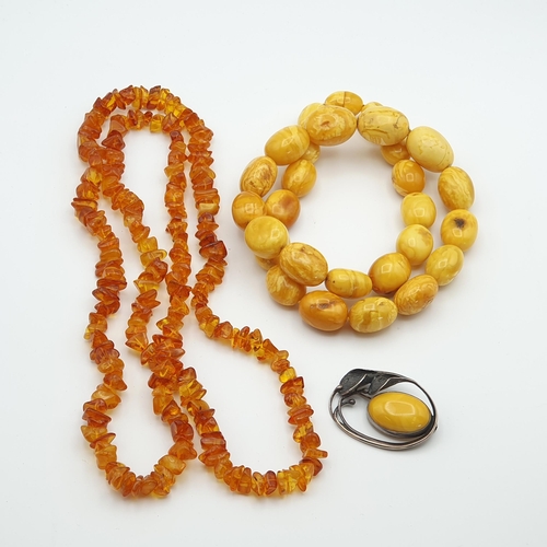281 - A yellow Amber bead Necklace, approx 135gms, a long modern Amber chip Necklace and a white metal sty... 