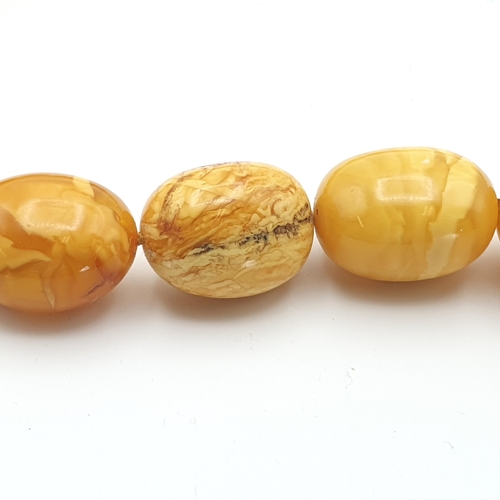 281 - A yellow Amber bead Necklace, approx 135gms, a long modern Amber chip Necklace and a white metal sty... 