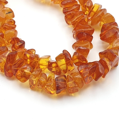 281 - A yellow Amber bead Necklace, approx 135gms, a long modern Amber chip Necklace and a white metal sty... 