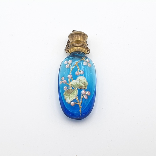 292 - A blue glass Scent Bottle with fruiting vine enamel decoration and gilt metal lid, 2 1/2 inches
