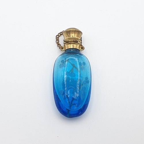 292 - A blue glass Scent Bottle with fruiting vine enamel decoration and gilt metal lid, 2 1/2 inches