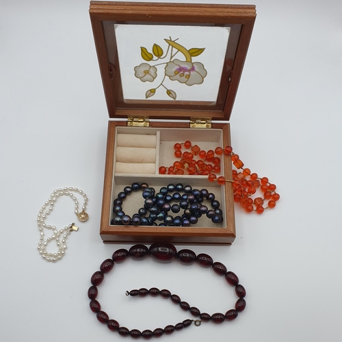 295 - A Cherry Amber type/ Bakelite style Bead Necklace, a further orange bead Necklace, a black freshwate... 