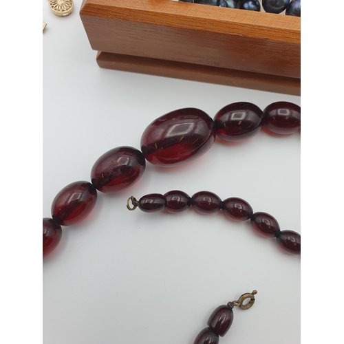 295 - A Cherry Amber type/ Bakelite style Bead Necklace, a further orange bead Necklace, a black freshwate... 