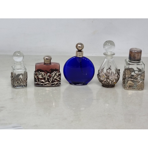 64 - An Elizabeth II silver mounted Bristol blue glass Scent Bottle, London 1987, and four clear glass Sc... 