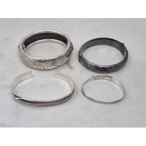 76 - Four various silver Bangles, two with leafage engraving, 95gms