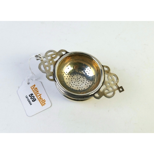 509 - Silver tea strainer and stand, +/- 64 grams