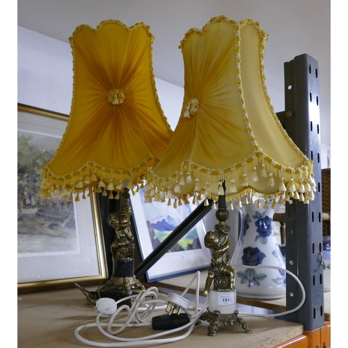 191 - Two cherub formed brass lamp bases with marble sections and ornate yellow shades