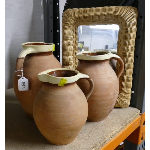 205 - Three graduated terracotta jugs and wicker framed mirror