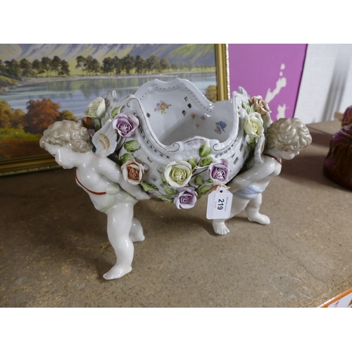 219 - Continental porcelain table centre of cherubs supporting a flower encrusted reticulated bowl, marked... 