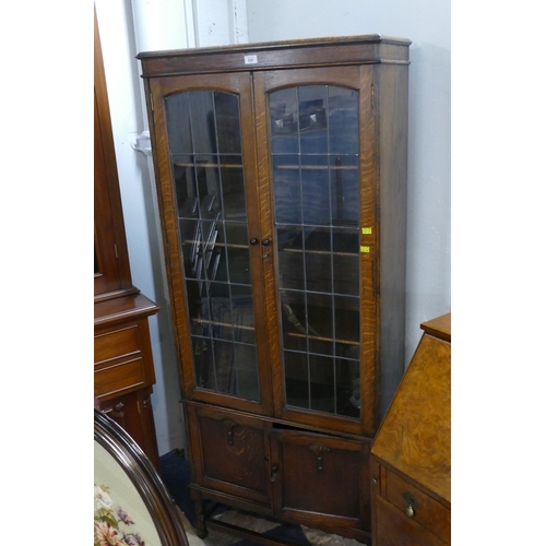 526 - Leaded glass fronted freestanding bookcase with cupboards to base