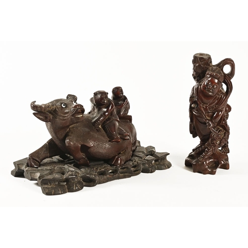 48 - An oriental carved figure of a Water Buffalo on stand, with glass eyes, together with a carved figur... 