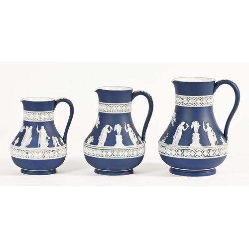 161 - A graduated set of three Wedgwood blue Jasperware jugs, impressed marks.  Tallest 20 cm.