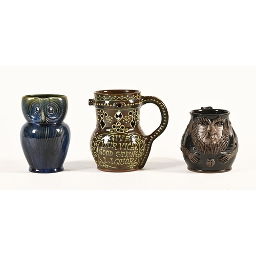 85 - A Bourne Denby owl jug, a puzzle jug and a grotesque mask jug.  Tallest 16 cm.