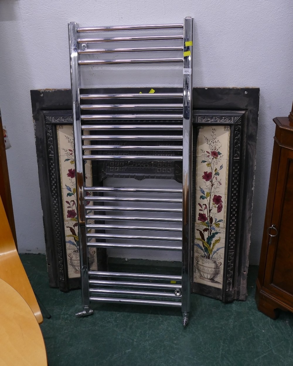 Metal fireplace insert with tiled surrounds and a bathroom radiator