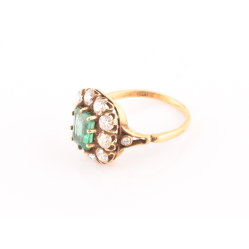 5 - An 18ct yellow gold, diamond, and emerald ring, centred with a mixed emerald-cut emerald of approxim... 