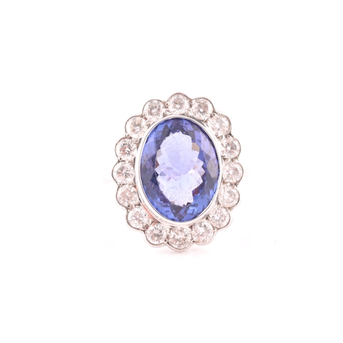 6 - An 18ct white gold, diamond, and tanzanite ring, set with a mixed oval-cut tanzanite, of approximate... 