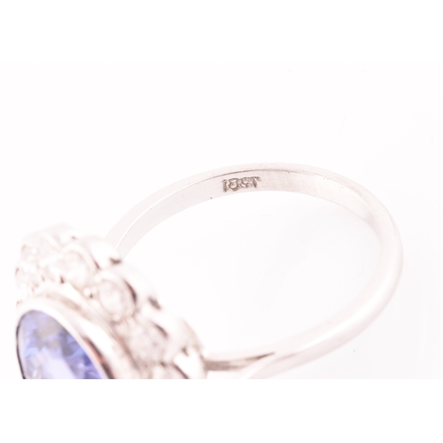 6 - An 18ct white gold, diamond, and tanzanite ring, set with a mixed oval-cut tanzanite, of approximate... 