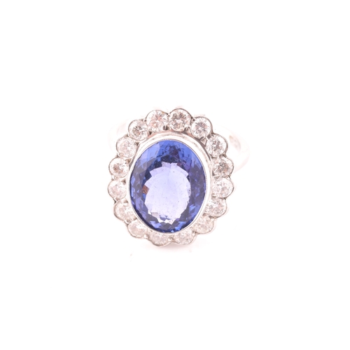 6 - An 18ct white gold, diamond, and tanzanite ring, set with a mixed oval-cut tanzanite, of approximate... 