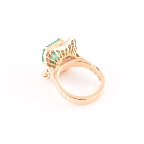 13 - An 18ct yellow gold, diamond, and emerald 'ballerina' cocktail ring, the waved mount inset with tape... 