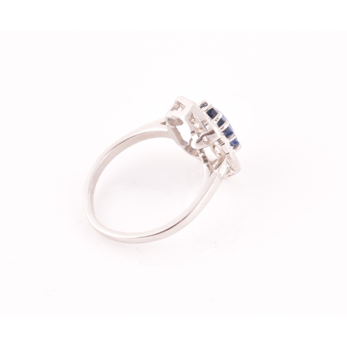 17 - A platinum, diamond, and sapphire ring, centred with a mixed oval-cut sapphire of approximately 1.65... 