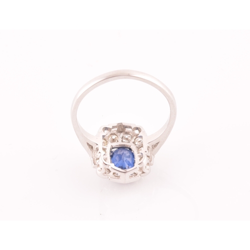 17 - A platinum, diamond, and sapphire ring, centred with a mixed oval-cut sapphire of approximately 1.65... 