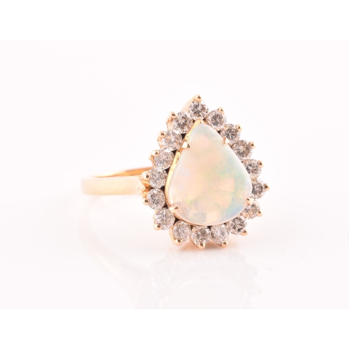 18 - An 18ct yellow gold, diamond, and opal ring, set with a teardrop shaped opal, within a border of rou... 