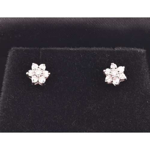 23 - A pair of 18ct white gold and diamond floral cluster earrings, approximately 6 mm diameter.