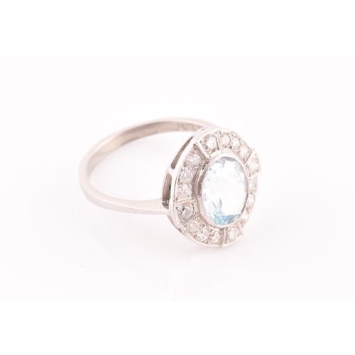 24 - A platinum, diamond, and aquamarine cluster ring, set with a mixed oval-cut aquamarine of approximat... 