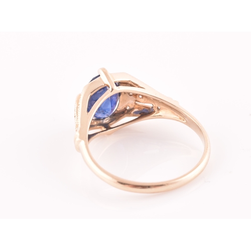 27 - A yellow metal and sapphire ring, set with a mixed oval-cut sapphire, the mount inset with round bri... 