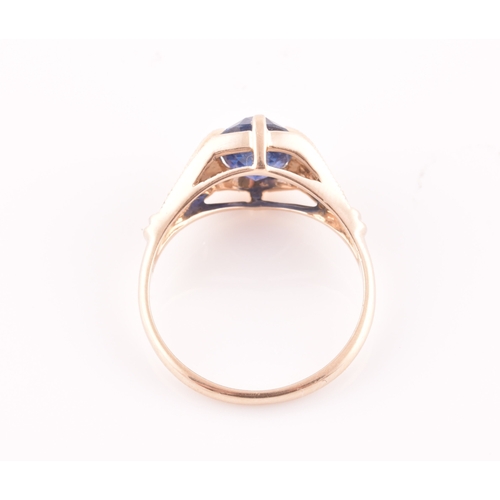 27 - A yellow metal and sapphire ring, set with a mixed oval-cut sapphire, the mount inset with round bri... 