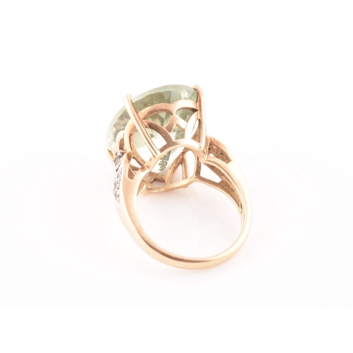 28 - A 9ct yellow gold and green quartz cocktail ring, set with a large mixed oval-cut green stone, with ... 