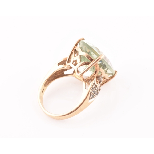 28 - A 9ct yellow gold and green quartz cocktail ring, set with a large mixed oval-cut green stone, with ... 