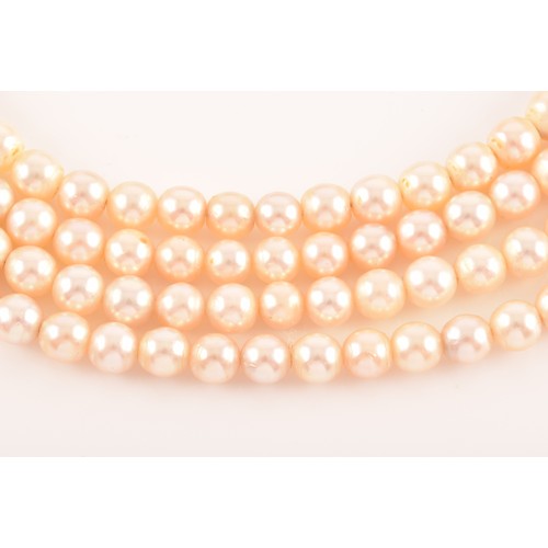 29 - A pearl choker necklace set with a diamond and aquamarine clasp, the quadruple strands formed of rou... 