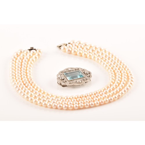 29 - A pearl choker necklace set with a diamond and aquamarine clasp, the quadruple strands formed of rou... 