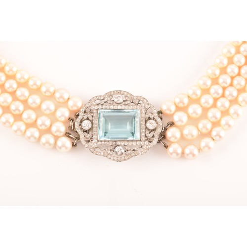 29 - A pearl choker necklace set with a diamond and aquamarine clasp, the quadruple strands formed of rou... 