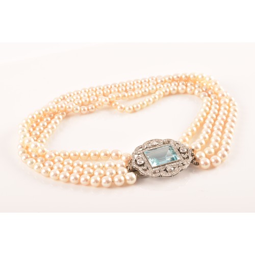 29 - A pearl choker necklace set with a diamond and aquamarine clasp, the quadruple strands formed of rou... 