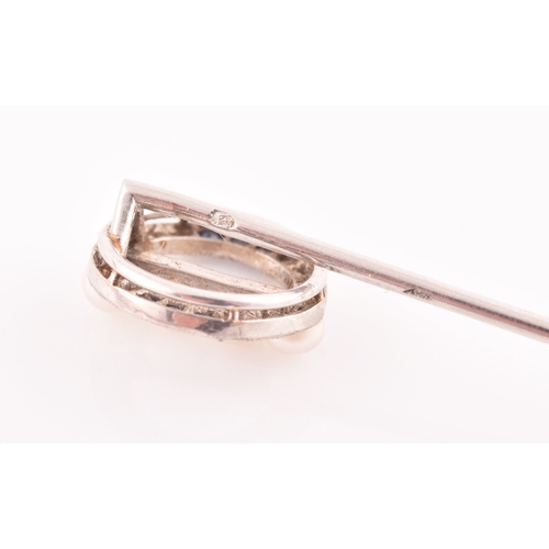 32 - Cartier. A white gold, diamond, and sapphire stick pin, the circular mount inset with calibre-set sa... 