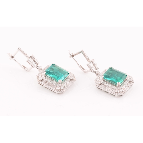 34 - A pair of 18ct white gold, diamond, and emerald pendant drop earrings, each set with a mixed emerald... 