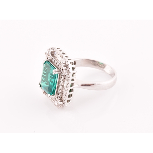 35 - An 18ct white gold, diamond, and emerald cocktail ring, set with a synthetic (hydrothermal) emerald-... 